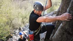 Älterer Kletterer am Fels