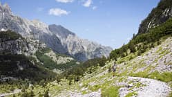 Wanderer auf einem Gebirgspfad beim Anstieg zum Pejes Pass zwischen Vusanje (Montenegro) und Theth (Albanien).