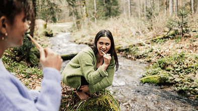 Zwei Frauen putzen Zähne am Bach