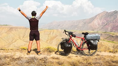 Radfahrer jubelt in Wüste 