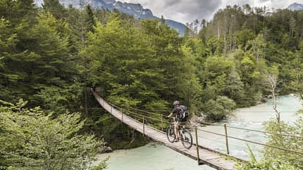 Male mountainbiker is crossing a suspension bridge in Slovenia. Male mountainbiker is crossing a suspension bridge in Slovenia.