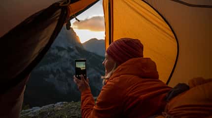 Frau im Zelt fotografiert mit Smartphone Frau im Zelt fotografiert mit Smartphone