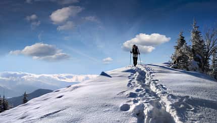 Frau wandert in den Bergen im Winter