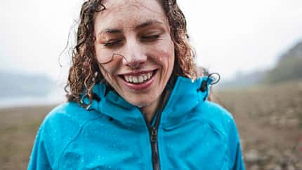 GettyImages/Howard Kingsnorth: femalesmiling in the rain 