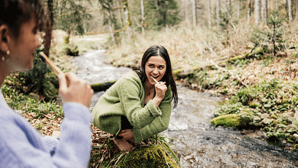 Zwei Frauen putzen Zähne am Bach