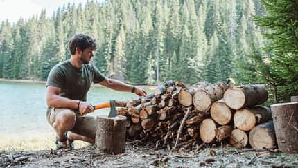 Holz hacken am See mit Axt und Beil