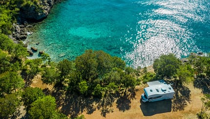 Luftaufnahme des malerischen Wohnmobil-Campingplatzes am Meer. Modernes Wohnmobil Van am Mittelmeer Kroatische Küste. Urlaub unterwegs. Türkisfarbene Bucht.
