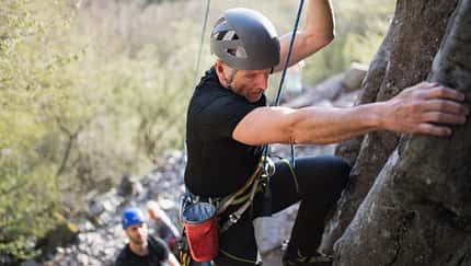 Älterer Kletterer am Fels