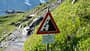 Steinschlaggefahr in den Alpen - Schild auf Wanderweg