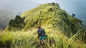 Young woman hikes through hilly jungle terrain