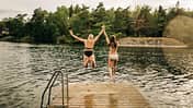 Zwei Frauen springen in den See - Sommerurlaub in Schweden