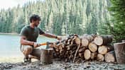Holz hacken am See mit Axt und Beil