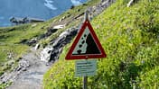 Steinschlaggefahr in den Alpen - Schild auf Wanderweg